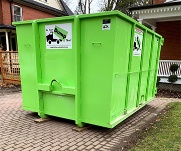 Clean, green dumpster rental on driveway